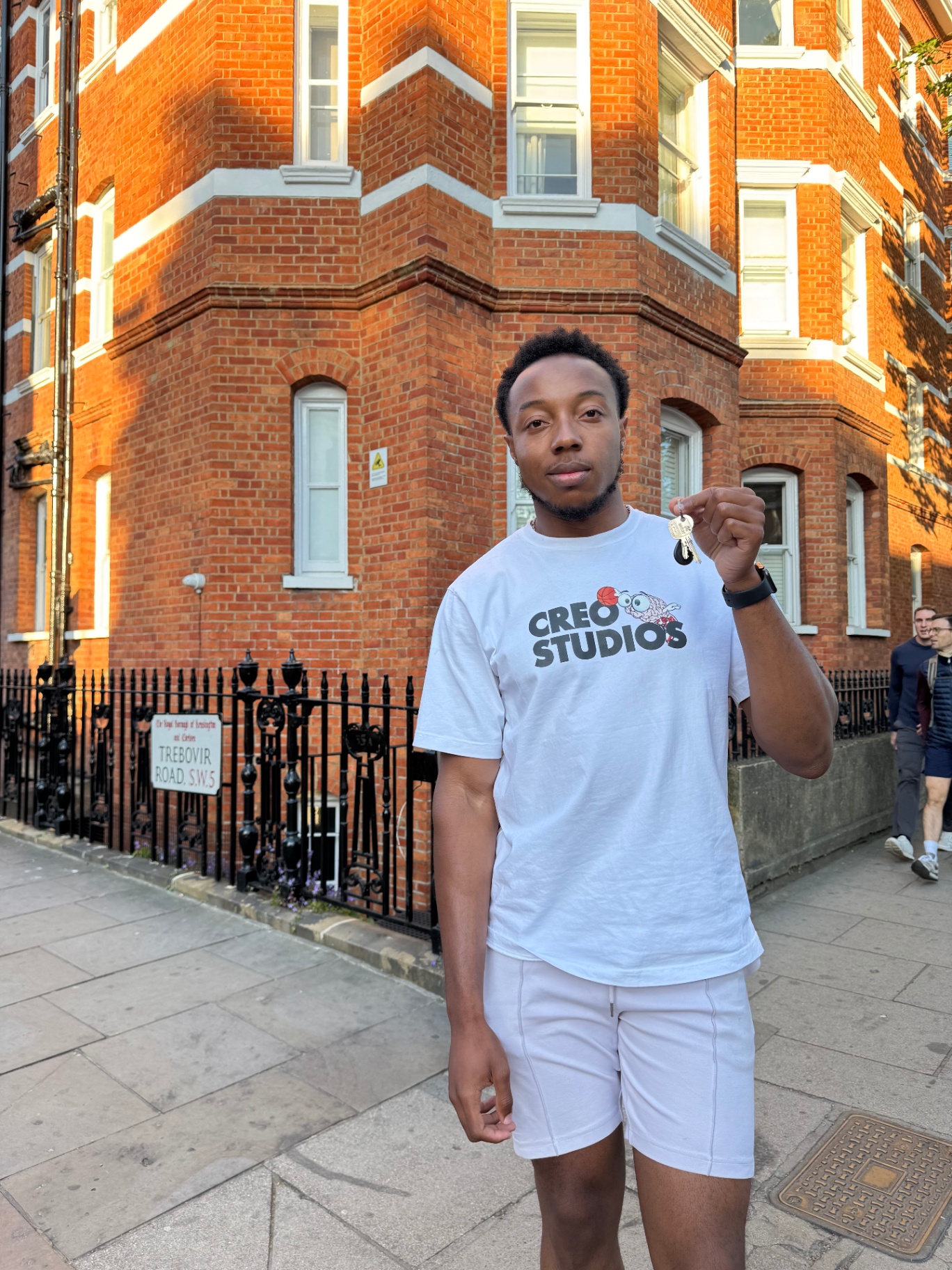 A KD-Living team member holding keys outside a Kensington property.